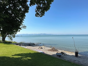 Une vue sur le lac, avec une zone herbeuse, un quai et un ciel dégagé.