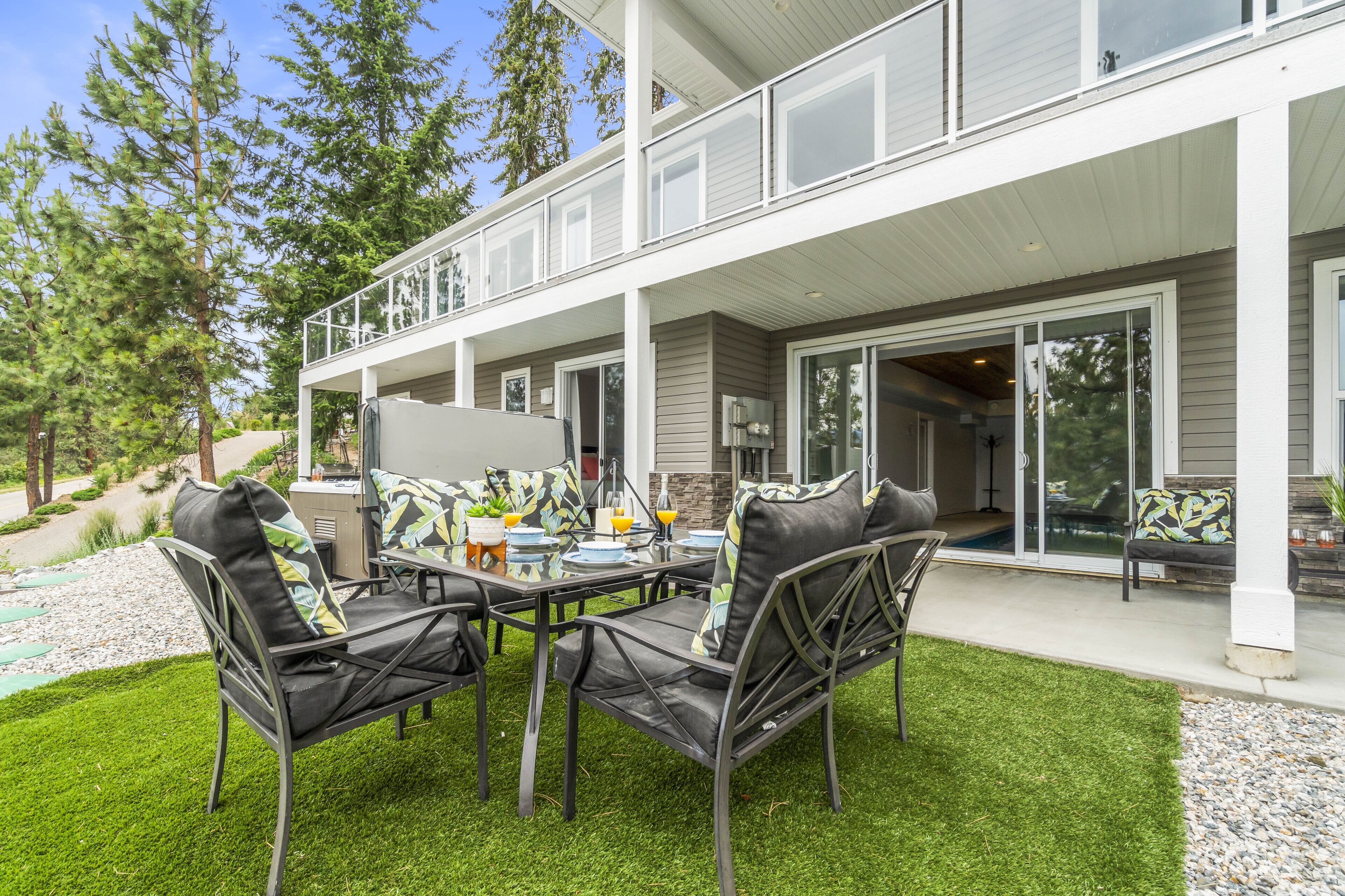 Eine Terrasse im Freien mit Esstisch, Stühlen und Grill.