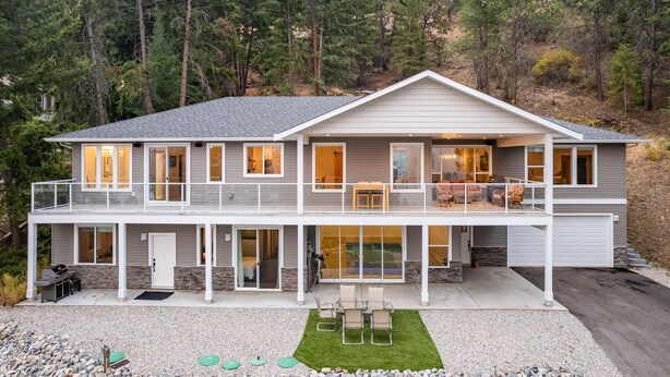 A two-story house with a balcony, a patio, and a garage. - Okanagan Lakeview Oasis, 2 Bed, 2 Bath, Sleeps 6 (Vernon)