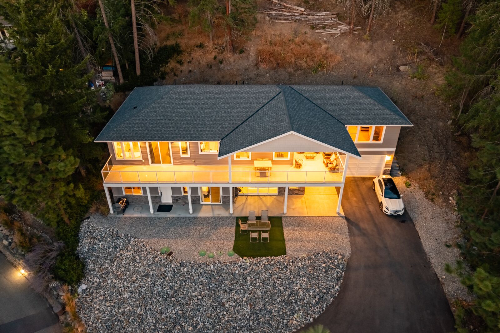 A two-story house with a covered patio and a driveway.