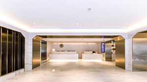 A spacious lobby with a reception desk, a large wall clock, and a modern design. - Ji Hotel Shanghai Jiuting Street (Shanghai)