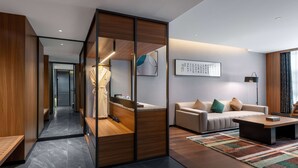 A modern living room with a sofa, coffee table, and a large mirror. - Tryp BY Wyndham Zizhou (Neijiang)
