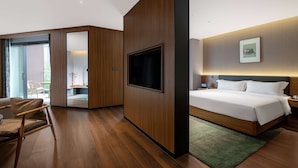 A modern hotel room with a large bed, a flat-screen TV, a wooden wall panel, and a view of the outside balcony. - Tryp BY Wyndham Zizhou (Neijiang)