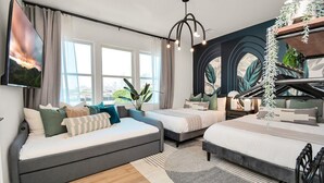 A modern bedroom with a sofa bed, two single beds, a large window, and a city view. - The Oasis Checkmate HTX Rooftop (Houston)