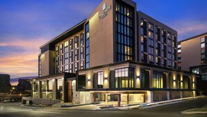A modern hotel building with a prominent "Cascade Hotel" sign, large windows, and a well-lit entrance. - Cascade Hotel, Kansas City, a Tribute Portfolio Hotel (Kansas City)