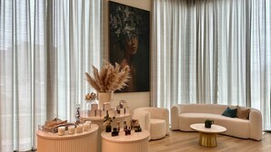 A modern living room with a beige sofa, a round coffee table, and a decorative centerpiece. - Cascade Hotel, Kansas City, a Tribute Portfolio Hotel (Kansas City)