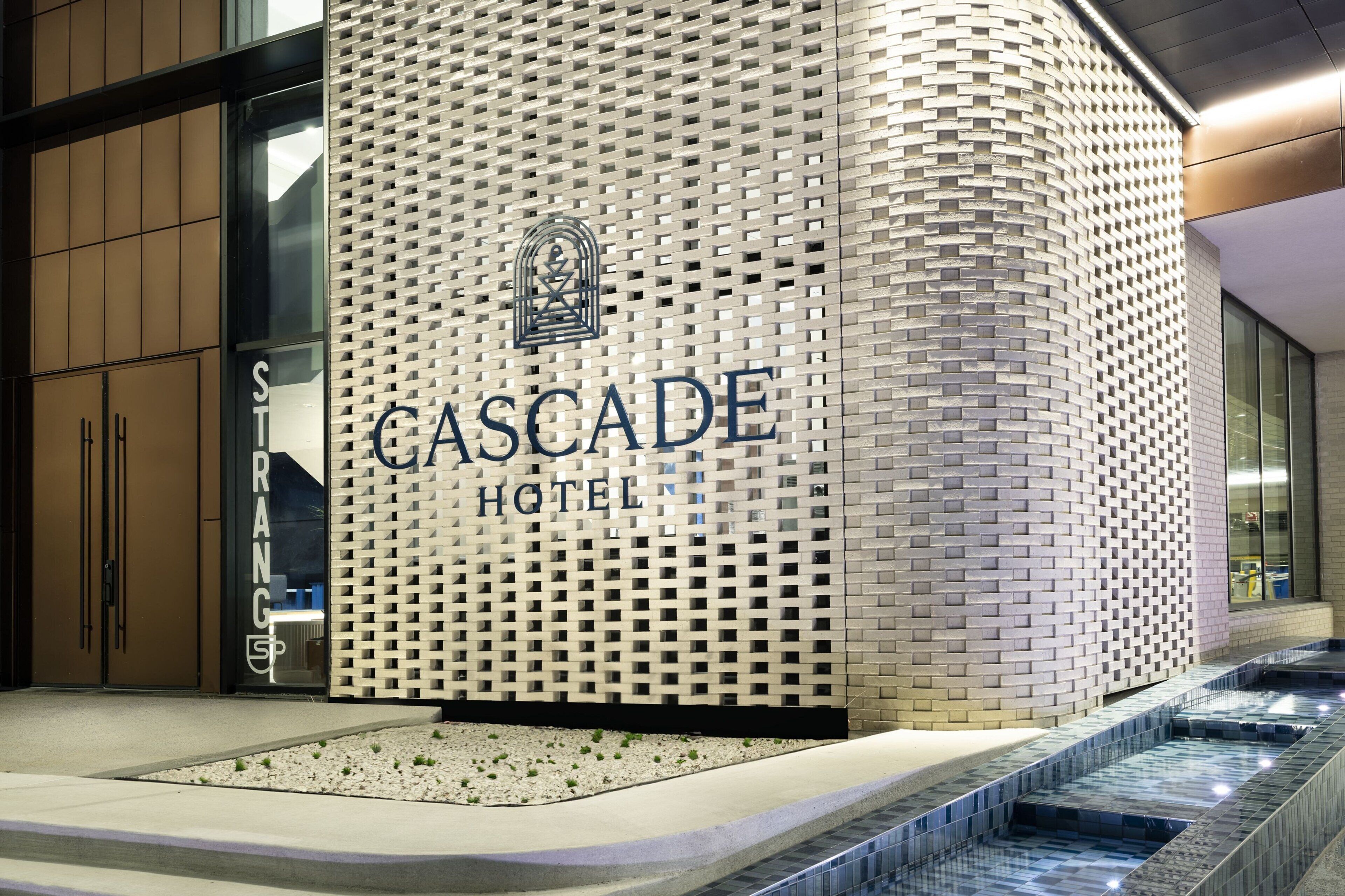 The exterior of the Cascade Hotel with a distinctive brick and lattice facade.