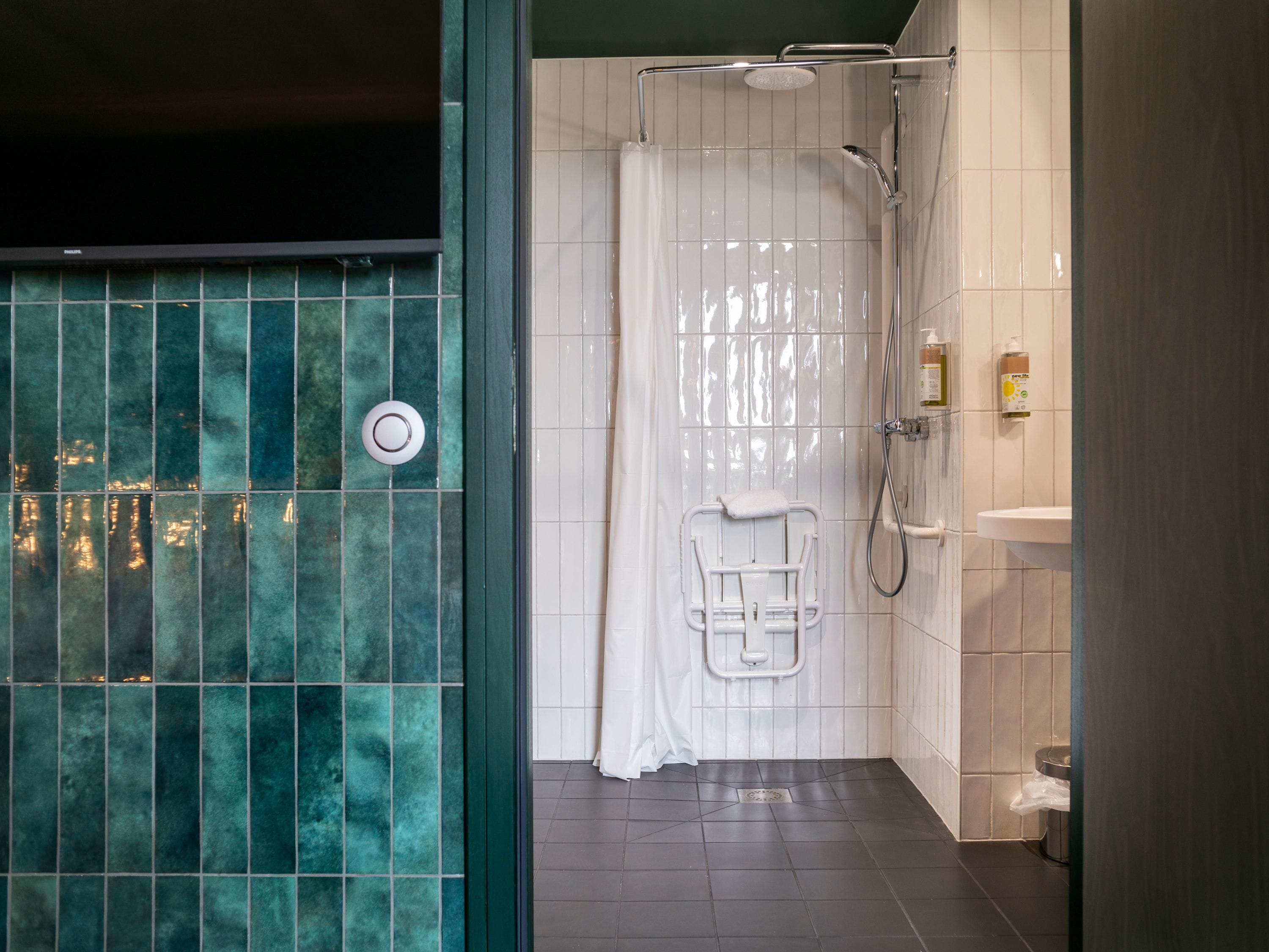 A modern bathroom with a shower, a toilet, and a sink.