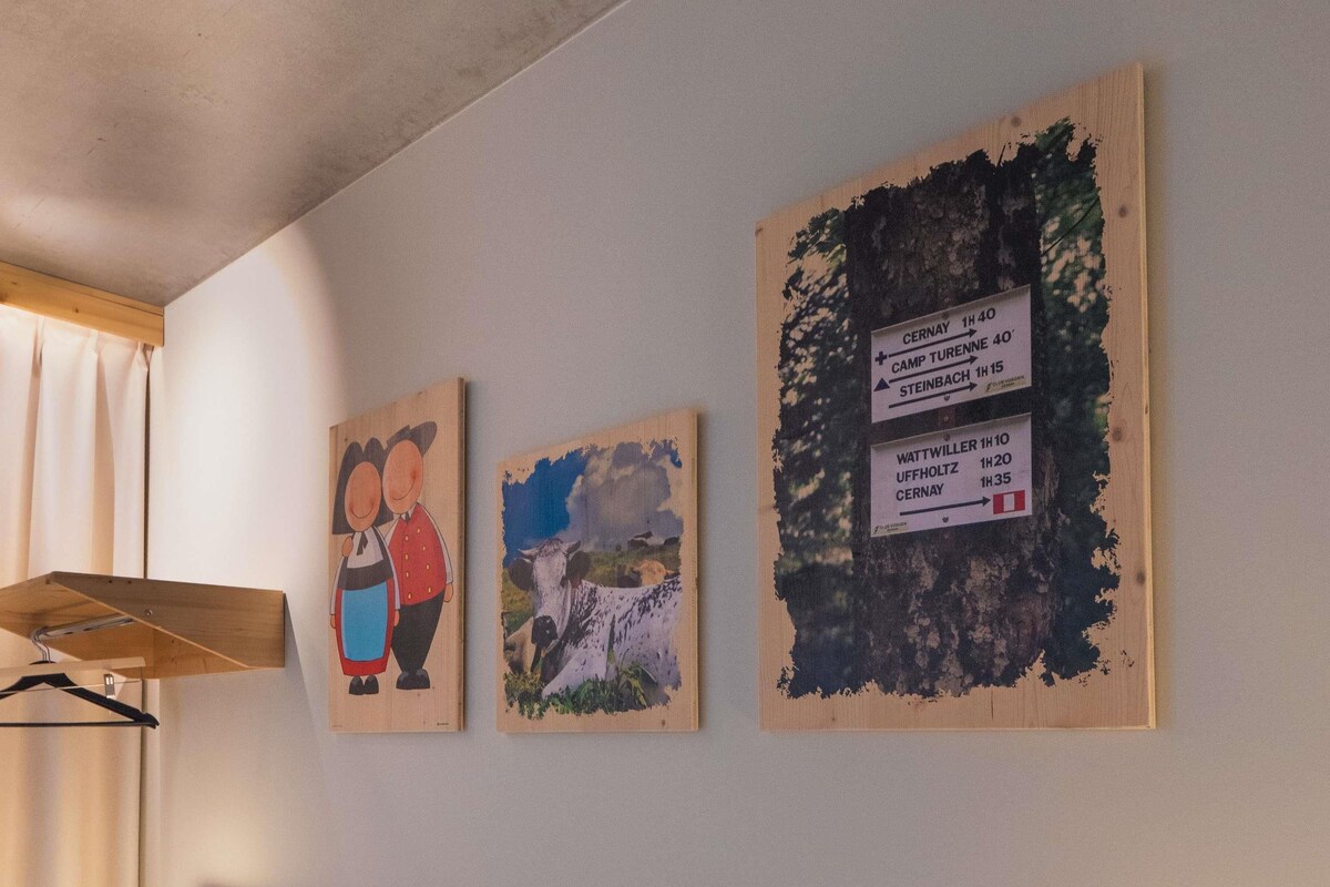 Three wooden signs with directional information on a wall.