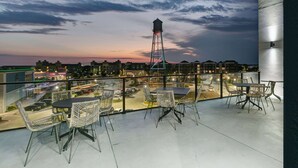 Eine Dachterrasse mit Außenbestuhlung, Blick auf die Stadt und ein Wasserwerk in der Ferne.