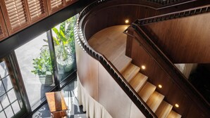 Una escalera de caracol con barandillas de madera y un suelo con estampado de cuadros.