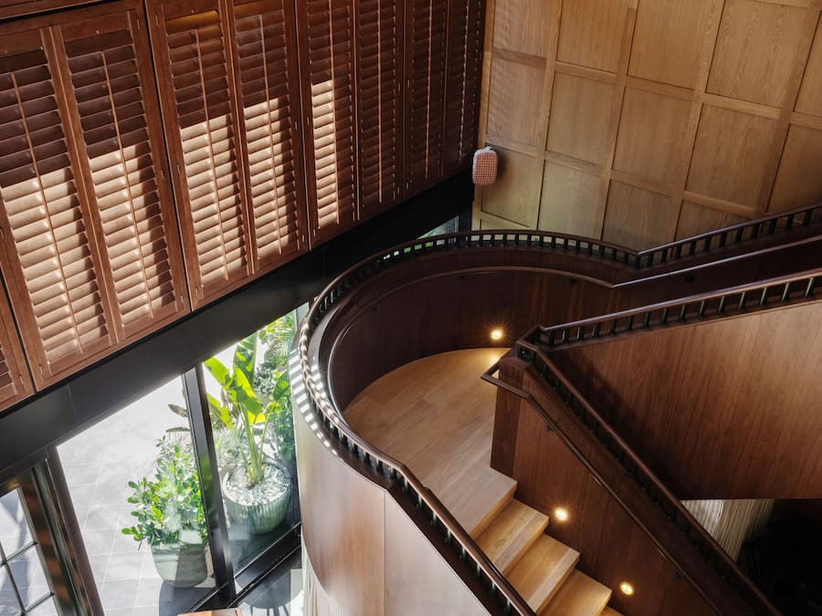 A spiral staircase with wooden railings and a checkered floor pattern.