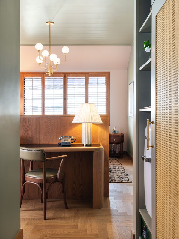 A wooden bar area with a lamp, a telephone, and a chair.