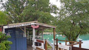 Ein hölzerner Pavillon mit einem Schild, auf dem 'Boissons Glaces Location' steht.