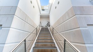 A modern staircase with metal railings leading to a landing.