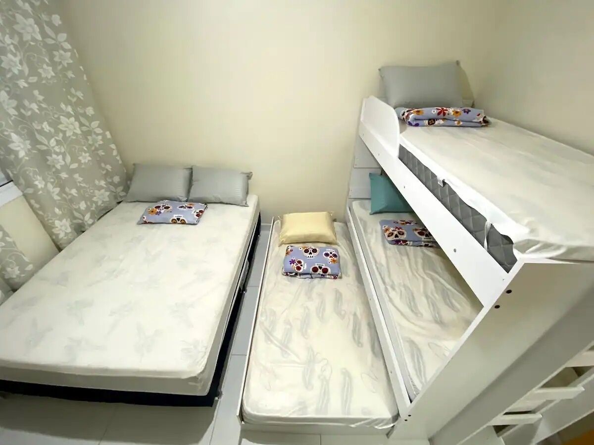 Une chambre avec deux lits superposés, chacun étant équipé d’un matelas et d’oreillers.