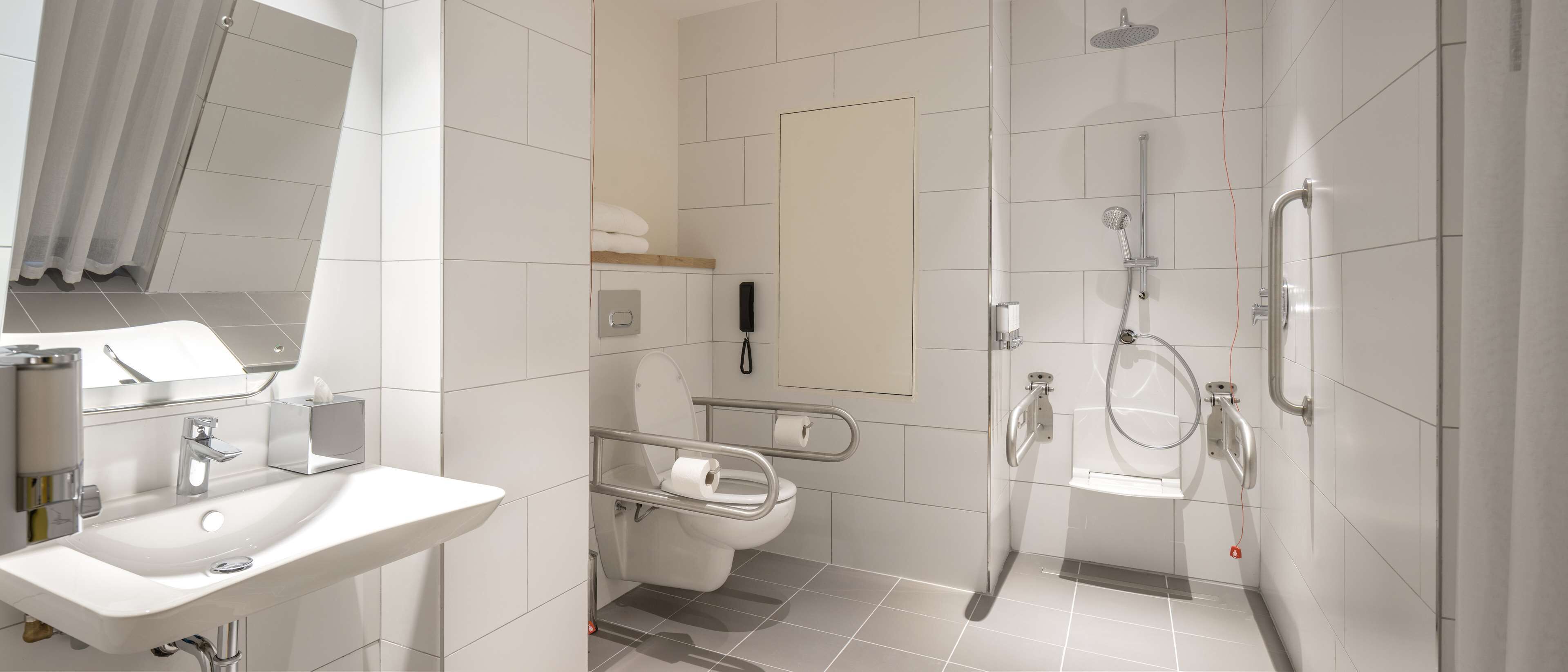 A modern bathroom with a sink, toilet, and shower.