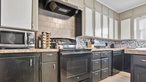 Une cuisine équipée d’un four à micro-ondes, d’une cuisinière et d’un lave-vaisselle.