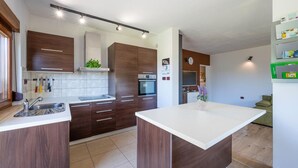 Eine moderne Küche mit dunklen Holzschränken, einer weißen Arbeitsplatte und einem eingebauten Backofen.