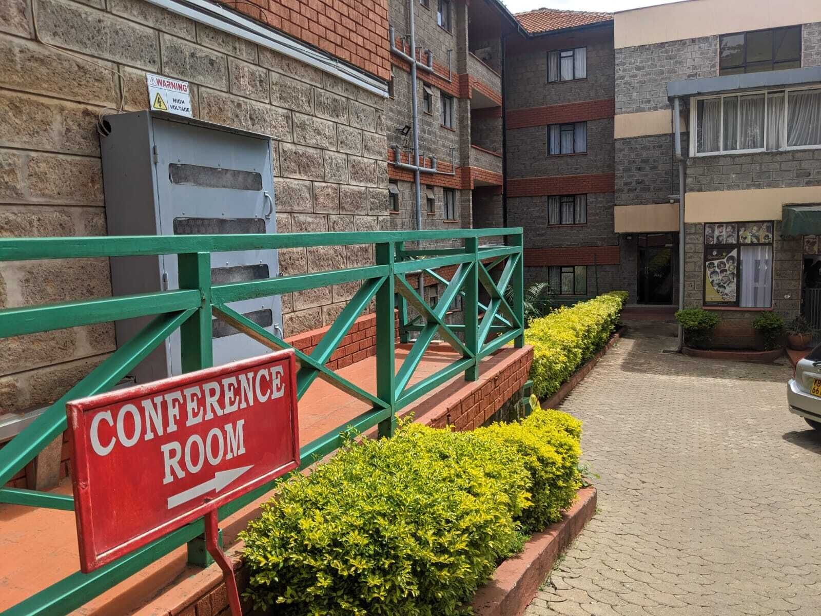 Un bâtiment sur lequel est apposée une enseigne indiquant la présence d’une salle de conférence.