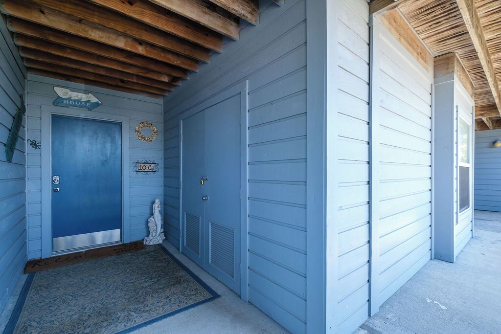 A building with a blue exterior, a wooden ceiling, and a blue door.