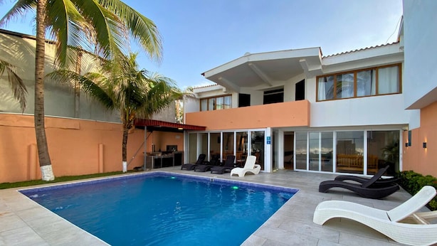 A modern house with a swimming pool, lounge chairs, and palm trees. - Quinta del Carmen (La Libertad)