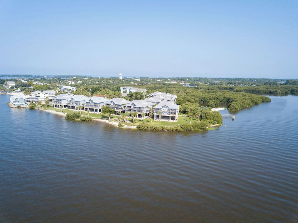 A waterfront property with multiple buildings, a dock, and a water body.