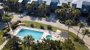 A resort with multiple buildings, a swimming pool, and palm trees. - Fenimore Mill 7A - Beautiful View, Pool, Hot Tub! (Cedar Key)