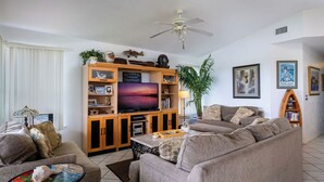 Ein Wohnzimmer mit Fernseher, Sofa und Couchtisch.