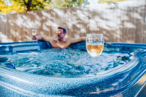 A hot tub with a glass of wine.