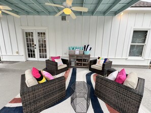 An outdoor seating area with wicker furniture and a patterned rug.