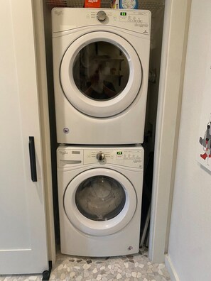 A compact laundry room with two stacked front-loading washing machines. - S Lamar Loft• King Bed •Tree Balcony• Pets• Zilker (Austin)