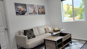 Ein Wohnzimmer mit einer Couch, einem Couchtisch und Kunstwerken, die berühmte Sehenswürdigkeiten zeigen.