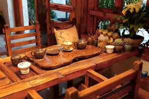Una mesa de madera con un juego de té y objetos decorativos.