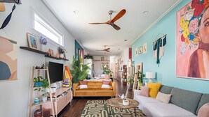 A living room with a sofa, coffee table, TV, and decorative items. - Chic Surroundings in Uptown New Orleans! (New Orleans)