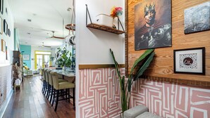 A modern interior with a dining area, a wooden accent wall, and a decorative shelf. - Chic Surroundings in Uptown New Orleans! (New Orleans)