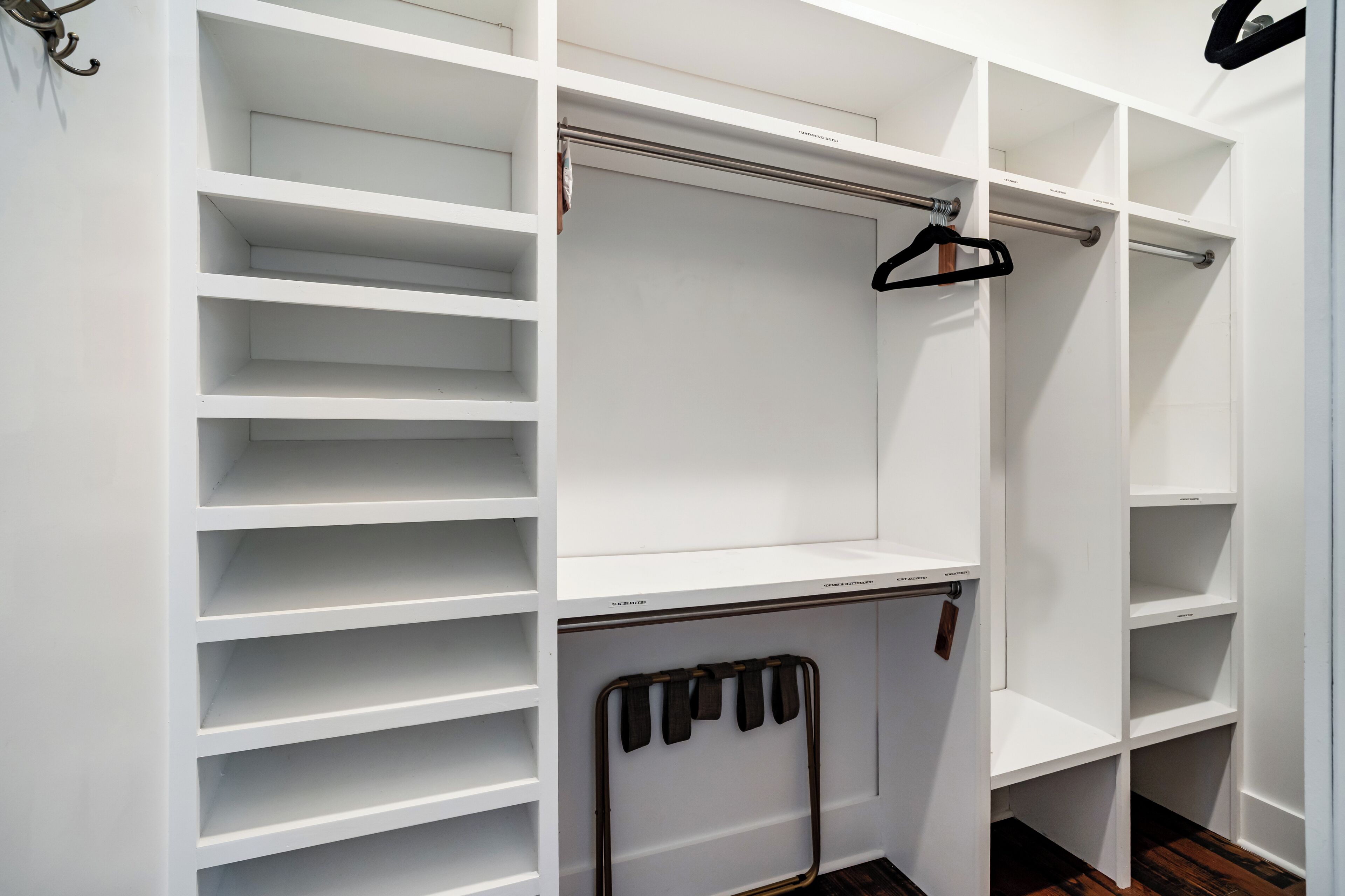 A white closet with multiple shelves and hanging space.