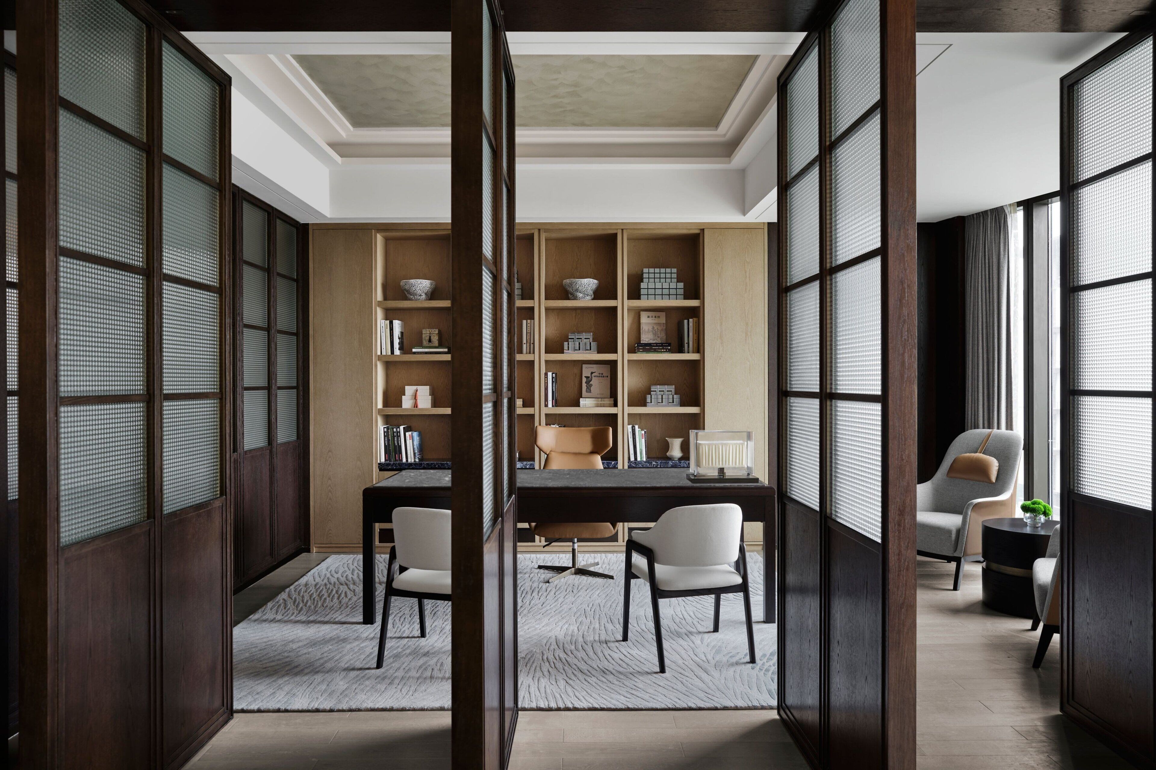 Una habitación tradicional japonesa con suelo de tatami, un escritorio de madera bajo y una zona de estar con cojines.
