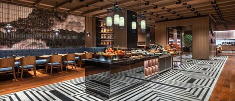A modern restaurant with a wooden ceiling, black and white patterned floor, and a buffet area.