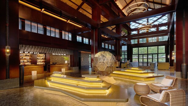 A spacious lobby with a modern design, featuring a central seating area with wicker chairs and a unique spherical light fixture. - Four Points By Sheraton Hainan, Qiongzhong (Qiongzhong County)