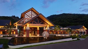 A modern hotel with a large entrance, a swimming pool, and a decorative spherical sculpture. - Four Points By Sheraton Hainan, Qiongzhong (Qiongzhong County)