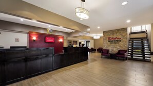A reception area with a desk, chairs, and a wall sign.