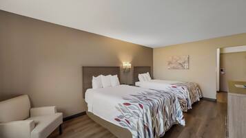 Habitación de hotel con dos camas, un sofá y un escritorio.
