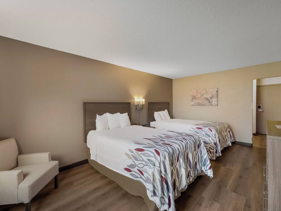 Habitación de hotel con dos camas, un sofá y un escritorio.