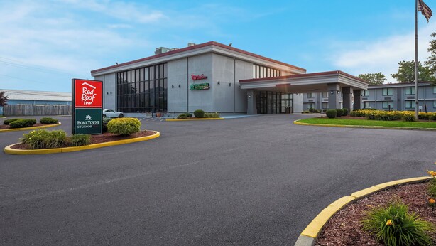 A Red Roof Inn with a large parking lot and a well-maintained lawn.