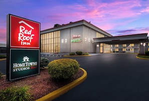 A hotel with a large sign for Red Roof Inn and Home Towne Studios.