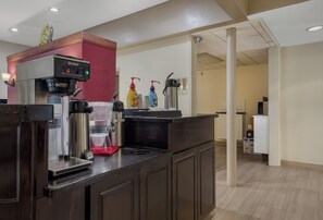 A coffee station with a Bunn coffee machine, a decaf dispenser, and a regular coffee dispenser.