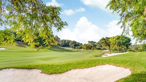A golf course with sand bunkers, trees, and a clear sky. - 2 bedroom beach front home in Orihuela Costa (Orihuela Costa)
