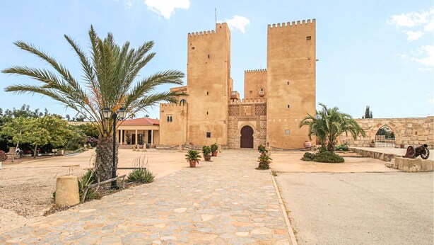 A historic building with two prominent towers, a paved entrance, and surrounding greenery. - 2 bedroom beach front home in Orihuela Costa (Orihuela Costa)
