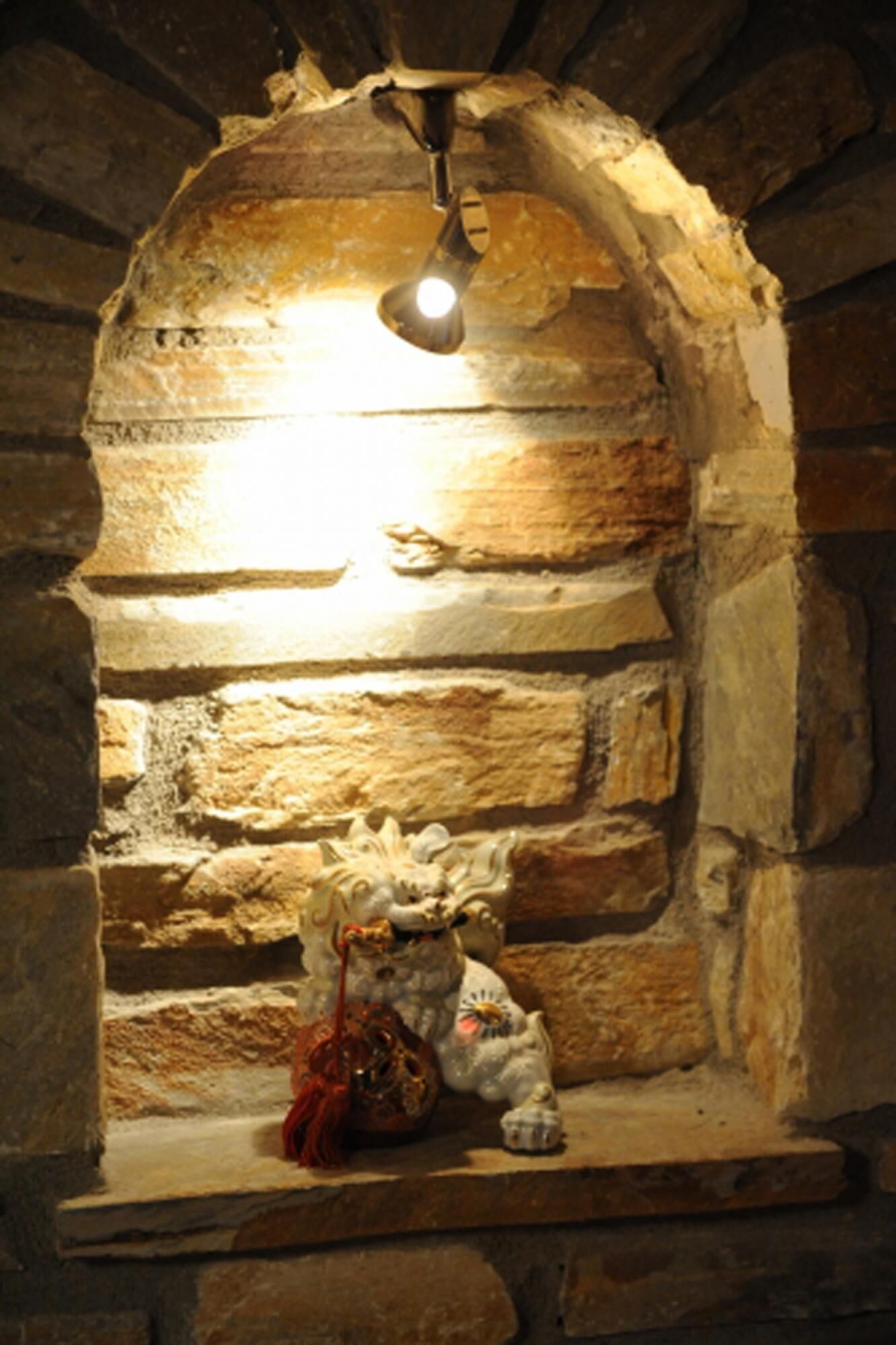 A stone fireplace with a hanging light fixture.